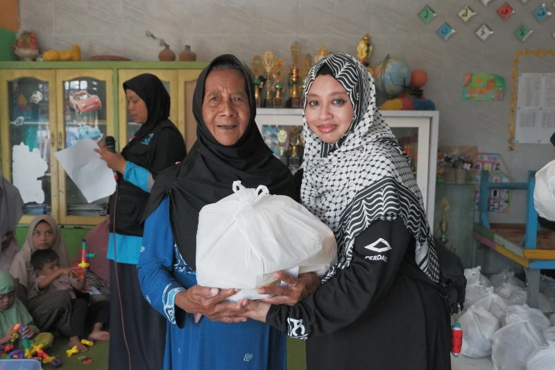 Volunteer distributing Qurban meat to recipient